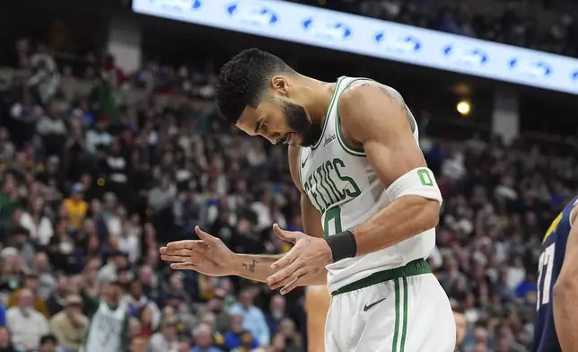 Boston Celtics forward Jayson Tatum reacts after dunking the ball for a basket and drawing a foul in the first half of an NBA basketball game against the Denver Nuggets, Tuesday, Jan. 7, 2025, in Denver. (AP Photo/David Zalubowski)