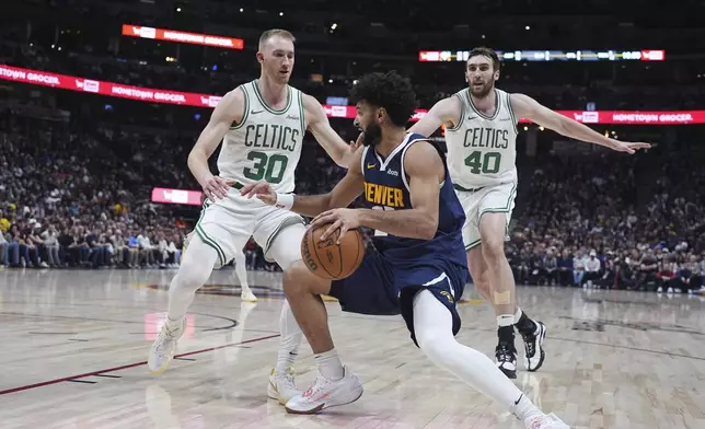 Denver Nuggets guard Jamal Murray, front drives to the basket as Boston Celtics forward Sam Hauser (30) and center Luke Kornet (40) defend in the second half of an NBA basketball game Tuesday, Jan. 7, 2025, in Denver. (AP Photo/David Zalubowski)