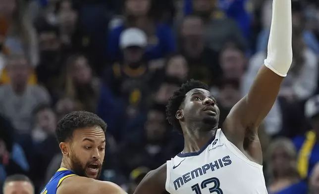 Memphis Grizzlies forward Jaren Jackson Jr., right, catches a pass while defended by Golden State Warriors forward Kyle Anderson, front left, during the first half of an NBA basketball game Saturday, Jan. 4, 2025, in San Francisco. (AP Photo/Godofredo A. Vásquez)