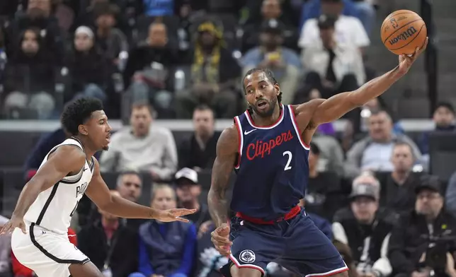 Los Angeles Clippers forward Kawhi Leonard, right, takes a pass as Brooklyn Nets guard Reece Beekman defends during the first half of an NBA basketball game, Wednesday, Jan. 15, 2025, in Inglewood, Calif. (AP Photo/Mark J. Terrill)