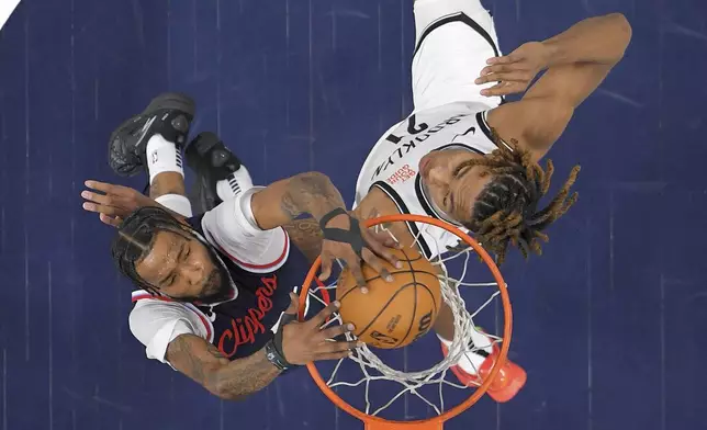 Los Angeles Clippers forward Derrick Jones Jr., left, dunks as Brooklyn Nets forward Noah Clowney defends during the first half of an NBA basketball game, Wednesday, Jan. 15, 2025, in Inglewood, Calif. (AP Photo/Mark J. Terrill)