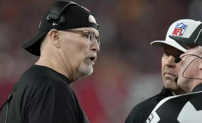 Washington Commanders head coach Dan Quinn, left, talks with officials during the first half of an NFL wild-card playoff football game against the Tampa Bay Buccaneers in Tampa, Fla., Sunday, Jan. 12, 2025. (AP Photo/Chris O'Meara)