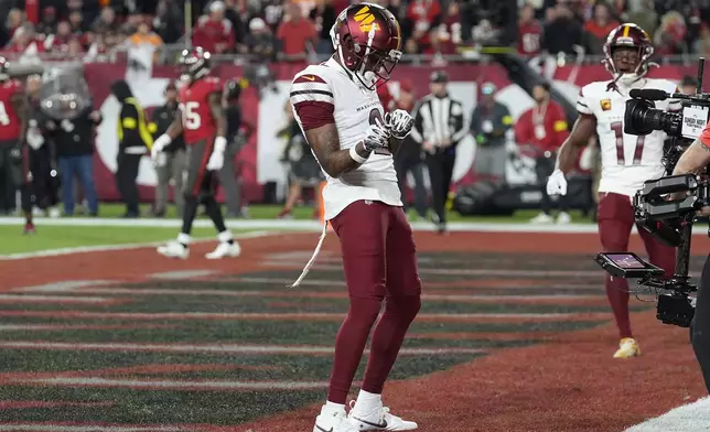 Washington Commanders wide receiver Dyami Brown, middle, celebrates after catching a touchdown pass against the Tampa Bay Buccaneers during the first half of an NFL wild-card playoff football game in Tampa, Fla., Sunday, Jan. 12, 2025. (AP Photo/Chris O'Meara)