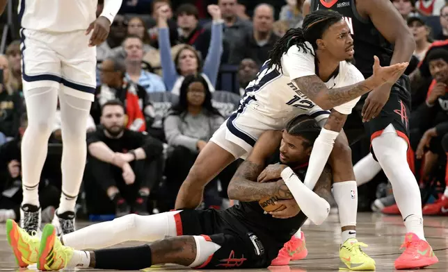 Memphis Grizzlies guard Ja Morant (12) and Houston Rockets guard Jalen Green struggle for control of the ball in the second half of an NBA basketball game, Thursday, Jan. 9, 2025, in Memphis, Tenn. (AP Photo/Brandon Dill)