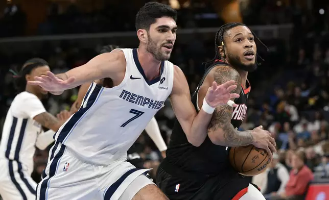 Houston Rockets forward Cam Whitmore, right, handles the ball against Memphis Grizzlies forward Santi Aldama (7) in the first half of an NBA basketball game Thursday, Jan. 9, 2025, in Memphis, Tenn. (AP Photo/Brandon Dill)