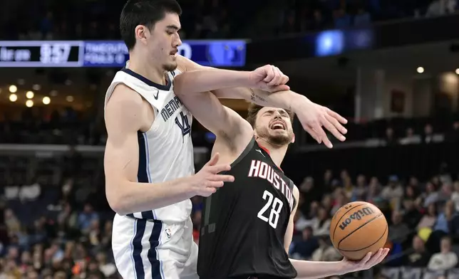 Houston Rockets center Alperen Sengun (28) handles the ball against Memphis Grizzlies center Zach Edey, left, in the first half of an NBA basketball game Thursday, Jan. 9, 2025, in Memphis, Tenn. (AP Photo/Brandon Dill)