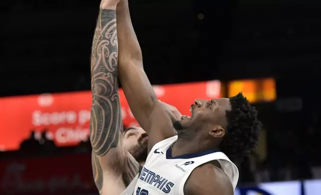 Memphis Grizzlies forward Jaren Jackson Jr. (13) and Houston Rockets center Steven Adams reach for a jump ball in the first half of an NBA basketball game, Thursday, Jan. 9, 2025, in Memphis, Tenn. (AP Photo/Brandon Dill)