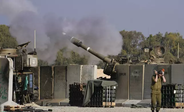 An Israeli soldier covers his ears as an artillery gunner fires into the Gaza Strip from a position in southern Israel, Thursday, Jan. 2, 2025.(AP Photo/Matias Delacroix)