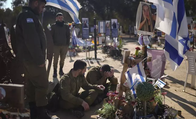 An Israeli soldier weeps in front of a memorial at the site of the Nova music festival, where hundreds of revelers were killed or kidnapped by Hamas, near Kibbutz Re'im in southern Israel, close to the Gaza Strip, Thursday, Jan. 2, 2025. (AP Photo/Matias Delacroix)