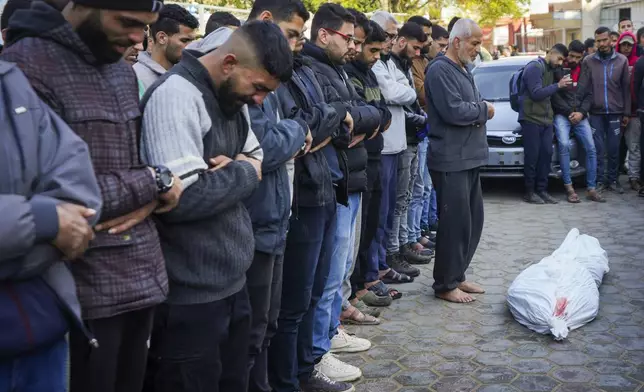 Palestinians pray over the body before the funeral of a man killed during an Israeli army strike in Deir al-Balah in the central Gaza Strip, Thursday Jan. 2, 2025.(AP Photo/Abdel Kareem Hana)