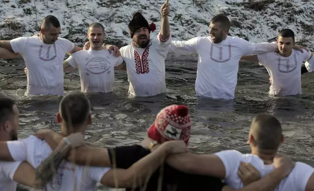 Bulgarians sing and dance in the Lesnovska River during Epiphany Day celebrations in the town of Elin Pelin, Bulgaria, Monday, Jan. 6, 2025. (AP Photo/Valentina Petrova)