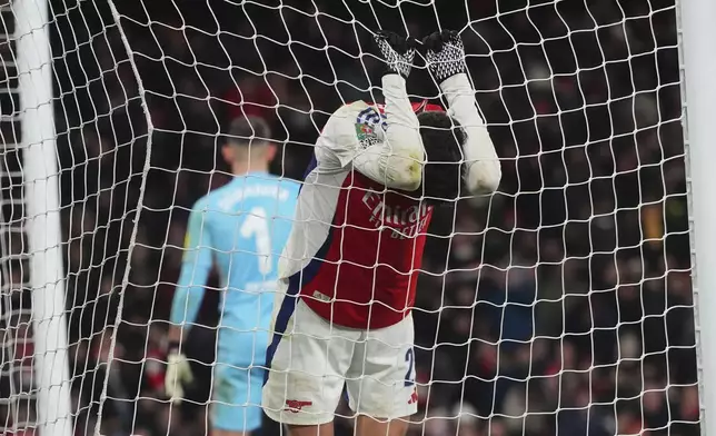 Arsenal's Kai Havertz, right, hangs on to the net after a missed opportunity on goal during the English League Cup semifinal first leg soccer match between Arsenal and Newcastle United at the Emirates stadium in London, Tuesday, Jan. 7, 2025. (AP Photo/Kirsty Wigglesworth)