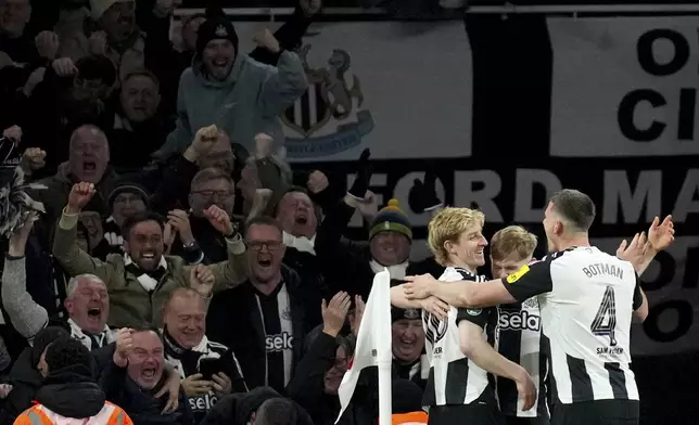 Newcastle's Anthony Gordon, left, is congratulated after scoring his sides second goal during the English League Cup semifinal first leg soccer match between Arsenal and Newcastle United at the Emirates stadium in London, Tuesday, Jan. 7, 2025. (AP Photo/Kirsty Wigglesworth)