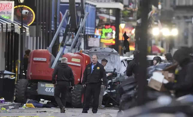 Security personnel investigate the scene on Bourbon Street after a vehicle drove into a crowd on New Orleans' Canal and Bourbon Street, Wednesday Jan. 1, 2025. (AP Photo/Gerald Herbert)