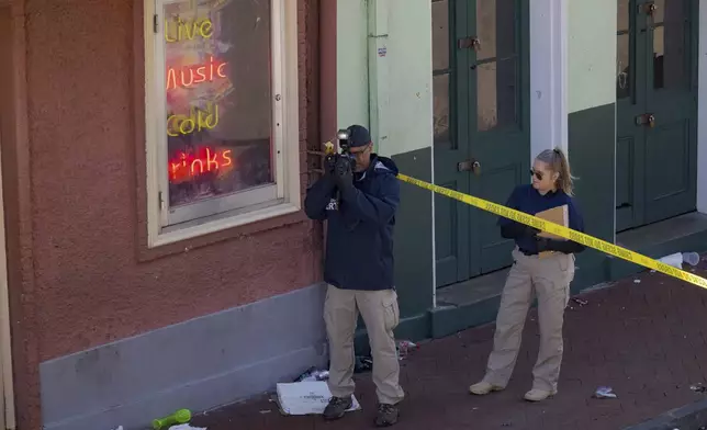 FBI members examine the scene on Bourbon Street during the investigation of a truck fatally crashing into pedestrians on Bourbon Street in the French Quarter in New Orleans, Wednesday, Jan. 1, 2025. (AP Photo/Matthew Hinton)