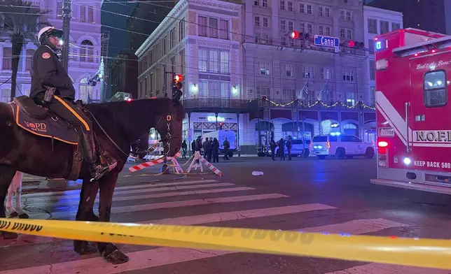 A mounted police officer arrives on Canal Street after a vehicle drove into a crowd earlier in New Orleans, Wednesday Jan. 1, 2025. (AP Photo/Kevin McGill)