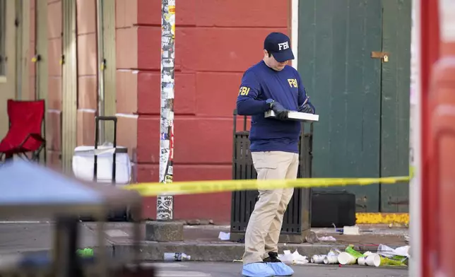 The FBI investigates the area on Orleans St and Bourbon Street by St. Louis Cathedral in the French Quarter where a suspicious package was detonated after a person drove a truck into a crowd earlier on Bourbon Street on Wednesday, Jan. 1, 2025. (AP Photo/Matthew Hinton)