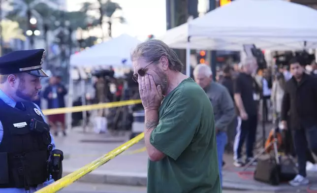 Edward Bruski, center, gets emotional at the scene where a vehicle drove into a crowd on New Orleans' Canal and Bourbon Street, Wednesday Jan. 1, 2025. (AP Photo/Gerald Herbert)