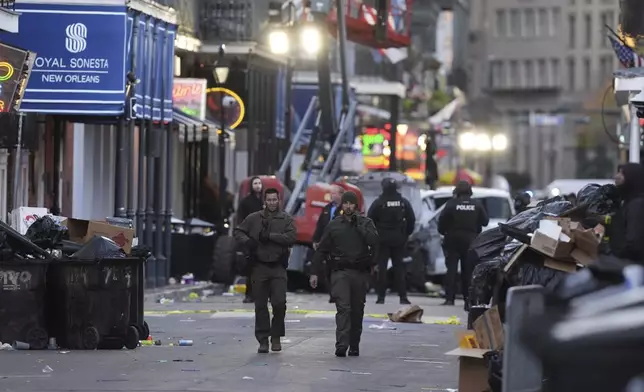 Emergency services attend the scene after a vehicle drove into a crowd on New Orleans' Canal and Bourbon Street, Wednesday Jan. 1, 2025. (AP Photo/Gerald Herbert)