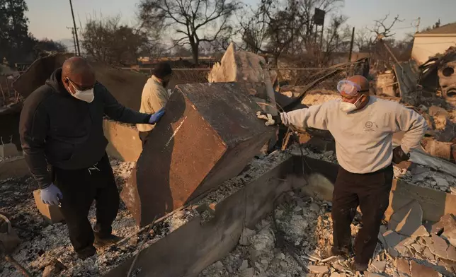 FILE - Kenneth Snowden, left, surveys the damage to his fire-ravaged property with his brother Kim, center, and Ronnie in the aftermath of the Eaton Fire on Friday, Jan. 10, 2025, in Altadena, Calif. (AP Photo/Jae C. Hong, File)