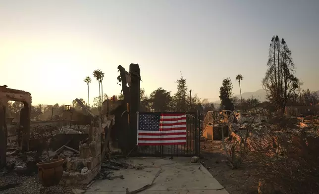 FILE - An American flag hangs on the gate of a home destroyed by the Eaton Fire in Altadena, Calif., Friday, Jan. 10, 2025. (AP Photo/Jae C. Hong, File)