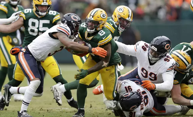 Green Bay Packers running back Josh Jacobs (8) runs against Chicago Bears safety Kevin Byard III, left, defensive tackle Chris Williams (91) and defensive tackle Gervon Dexter Sr. (99) during the first half of an NFL football game, Sunday, Jan. 5, 2025, in Green Bay, Wis. (AP Photo/Matt Ludtke)