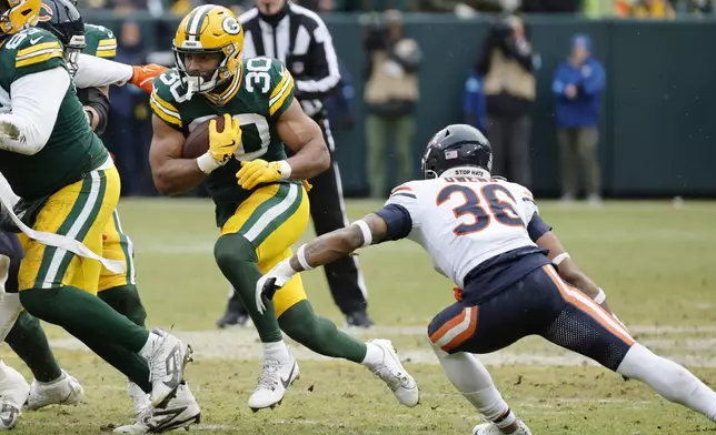 Green Bay Packers running back Chris Brooks (30) runs against Chicago Bears safety Jonathan Owens (36) during the first half of an NFL football game, Sunday, Jan. 5, 2025, in Green Bay, Wis. (AP Photo/Mike Roemer)