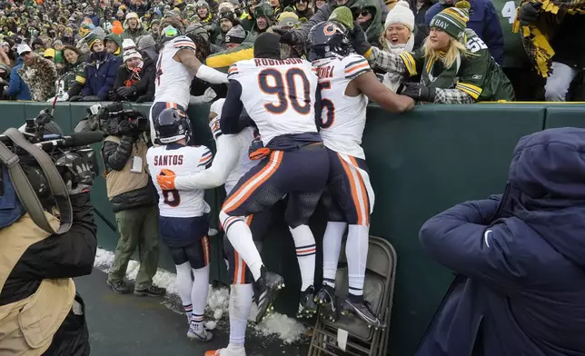 Chicago Bears players celebrate in front of fans at Lambeau Field after defeating the Green Bay Packers in an NFL football game, Sunday, Jan. 5, 2025, in Green Bay, Wis. (AP Photo/Morry Gash)