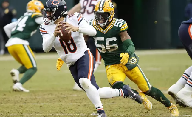 Chicago Bears quarterback Caleb Williams (18) scrambles away from Green Bay Packers linebacker Edgerrin Cooper (56) during the second half of an NFL football game, Sunday, Jan. 5, 2025, in Green Bay, Wis. (AP Photo/Mike Roemer)