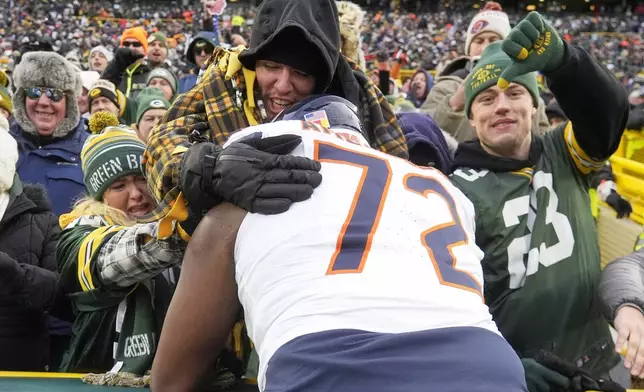 Chicago Bears' Kiran Amegadjie jumps in the crowd after an NFL football game against the Green Bay Packers Sunday, Jan. 5, 2025, in Green Bay, Wis. (AP Photo/Morry Gash)