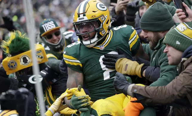 Green Bay Packers running back Josh Jacobs celebrates with fans after scoring against the Chicago Bears during the first half of an NFL football game, Sunday, Jan. 5, 2025, in Green Bay, Wis. (AP Photo/Matt Ludtke)