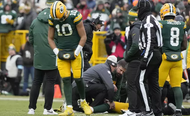 Green Bay Packers quarterback Jordan Love (10) reacts as wide receiver Christian Watson, bottom, is checked on during the first half of an NFL football game against the Chicago Bears, Sunday, Jan. 5, 2025, in Green Bay, Wis. (AP Photo/Morry Gash)