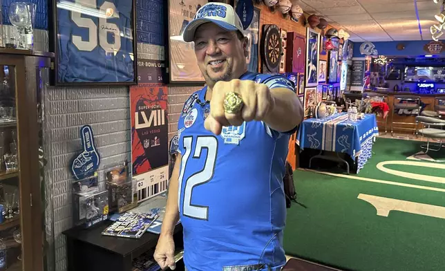 Detroit Lions fan Rob Gonzales displays a replica 1957 NFL football championship ring while standing in the basement of his home Thursday, Jan. 16, 2025, in Frenchtown Township, Mich. (AP Photo/Mike Householder)