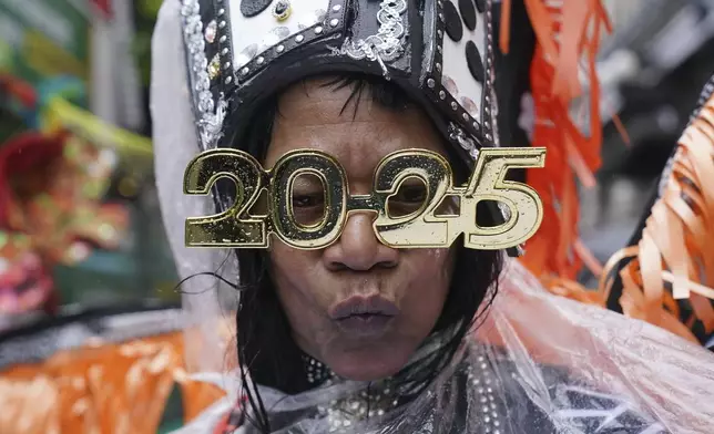 A performer walks in the rain during the New Year's Day Parade in central London, Wednesday Jan. 1, 2025. (Jonathan Brady/PA via AP)