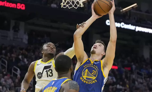 Golden State Warriors center Quinten Post (21) is fouled by Utah Jazz guard Isaiah Collier (13) during the first half of an NBA basketball game in San Francisco, Tuesday, Jan. 28, 2025. (AP Photo/Jeff Chiu)