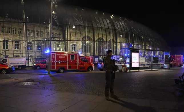 A soldier guards the train station after two trams collided, injuring dozens of people, though none critically, firefighters said, Saturday, Jan. 11, 2025 in Strasbourg, eastern France. (AP Photo/Pascal Bastien)