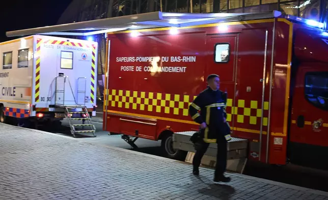 A firefighter rushes to the train station after two trams collided, injuring dozens of people, though none critically, firefighters said, Saturday, Jan. 11, 2025 in Strasbourg, eastern France. (AP Photo/Pascal Bastien)