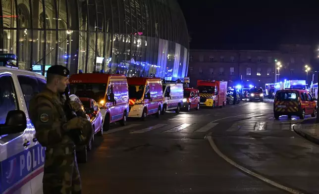 A soldier guards the train station after two trams collided, injuring dozens of people, though none critically, firefighters said, Saturday, Jan. 11, 2025 in Strasbourg, eastern France. (AP Photo/Pascal Bastien)