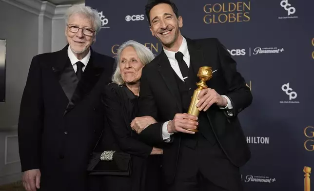 Elliot Brody, from left, Sylvia Plachy, and Adrien Brody, winner of the award for best performance by a male actor in a motion picture drama for "The Brutalist", pose in the press room during the 82nd Golden Globes on Sunday, Jan. 5, 2025, at the Beverly Hilton in Beverly Hills, Calif. (AP Photo/Chris Pizzello)