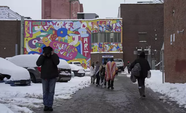 People walk toward a daytime warming shelter, Tuesday, Jan. 7, 2025, in Cincinnati. (AP Photo/Joshua A. Bickel)