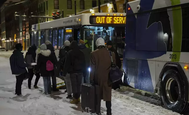 People board a bus to an overnight shelter during a winter storm, Monday, Jan. 6, 2025, in Cincinnati. (AP Photo/Joshua A. Bickel)