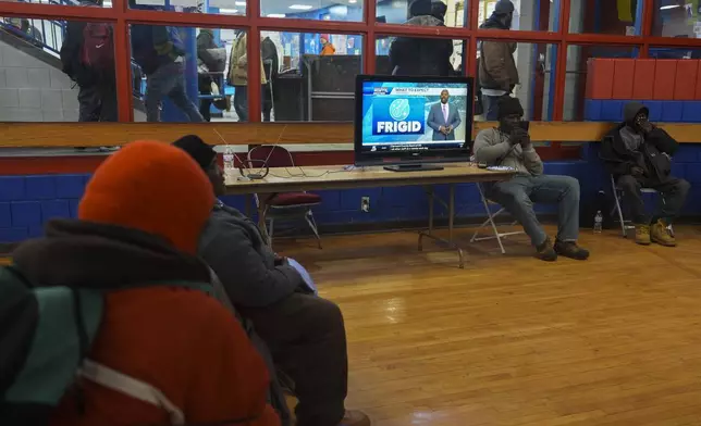 Patrons watch a local weather report while sheltering from the cold inside a recreation center, Monday, Jan. 6, 2025, in Cincinnati. (AP Photo/Joshua A. Bickel)