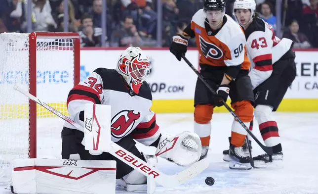 New Jersey Devils' Jake Allen, left, cannot block a goal by Philadelphia Flyers' Garnet Hathaway during the second period of an NHL hockey game, Monday, Jan. 27, 2025, in Philadelphia. (AP Photo/Matt Slocum)