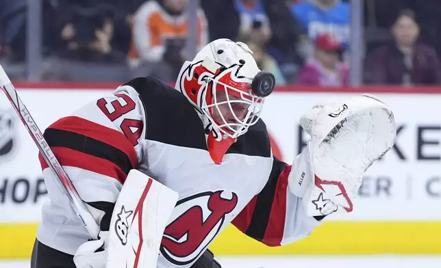 New Jersey Devils' Jake Allen blocks a shot during the second period of an NHL hockey game against the Philadelphia Flyers, Monday, Jan. 27, 2025, in Philadelphia. (AP Photo/Matt Slocum)