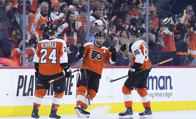 Philadelphia Flyers' Scott Laughton, center, celebrates with Joel Farabee, right, and Nick Seeler after scoring a goal during the third period of an NHL hockey game against the New Jersey Devils, Monday, Jan. 27, 2025, in Philadelphia. (AP Photo/Matt Slocum)