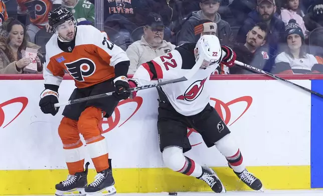 New Jersey Devils' Brett Pesce, right, collides with Philadelphia Flyers' Noah Cates during the first period of an NHL hockey game, Monday, Jan. 27, 2025, in Philadelphia. (AP Photo/Matt Slocum)