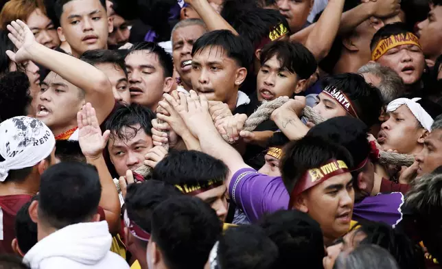 Devotees grab the rope as they pull a glass-covered carriage carrying the image of Jesus Nazareno during its annual procession in Manila, Philippines Thursday, Jan. 9, 2025. (AP Photo/Basilio Sepe)