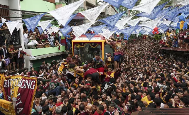 Devotees pull a glass-covered carriage carrying the image of Jesus Nazareno during its annual procession in Manila, Philippines Thursday, Jan. 9, 2025. (AP Photo/Basilio Sepe)