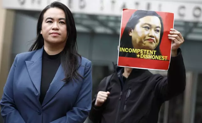 Former Oakland Mayor Sheng Thao stands in front of the United States District Court for a press conference following her arraignment of federal charges in Oakland, Calif., Friday, Jan. 17, 2025, as Tuan Ngo, founder of Asians Unite, protests at right. (Santiago Mejia/San Francisco Chronicle via AP)