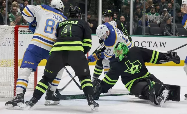 Buffalo Sabres left wing Jason Zucker scores a goal against Dallas Stars goaltender Casey DeSmith as Sabres right wing Alex Tuch and Stars defenseman Miro Heiskanen (4), look on, during the second period of an NHL hockey game in Dallas, Tuesday, Dec. 31, 2024. (AP Photo/Michael Ainsworth)